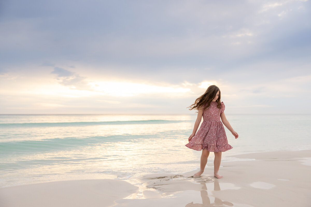 A young girl playing in the shallow waves
