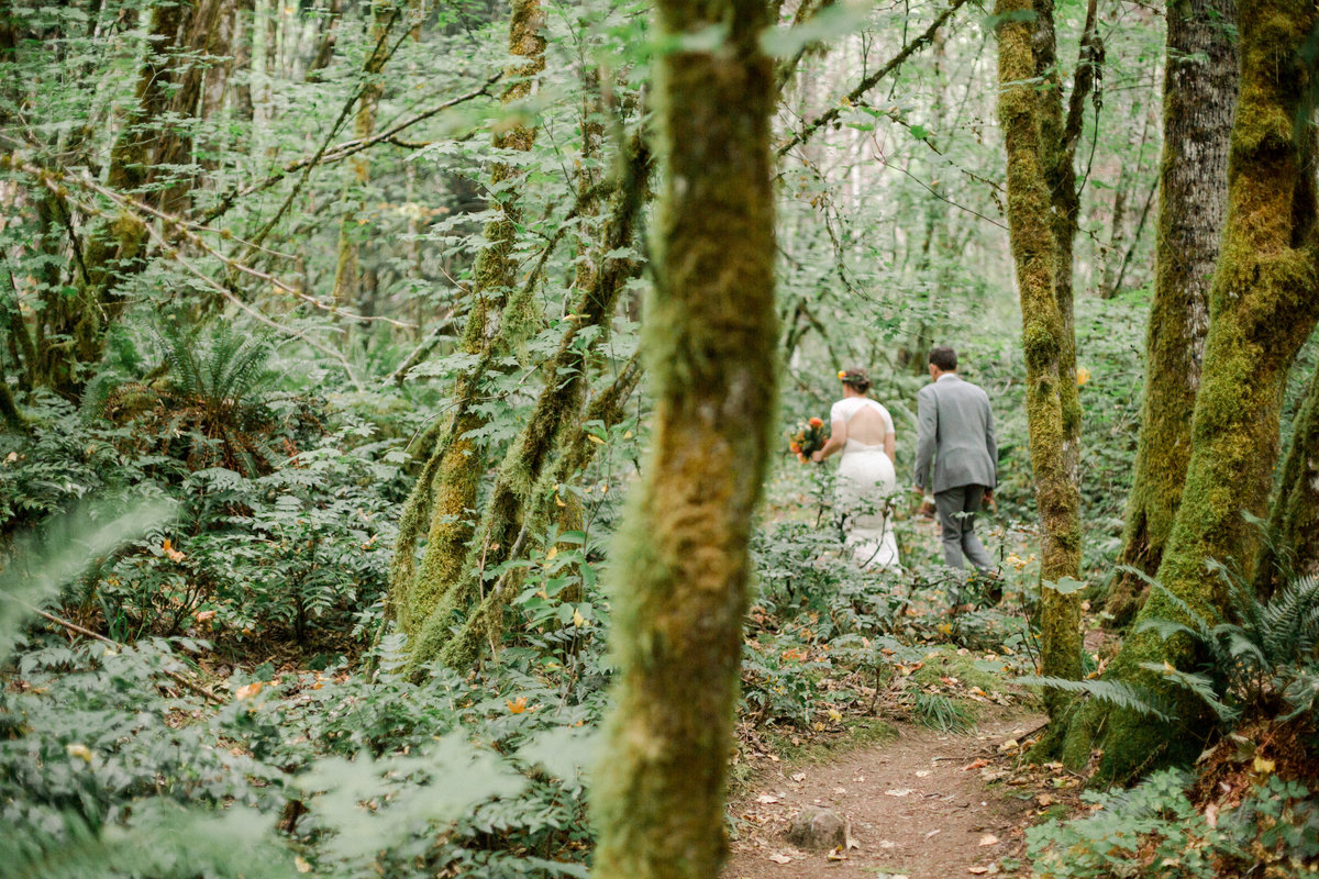 couple walks through woods after ceremony at wellspring spa washington