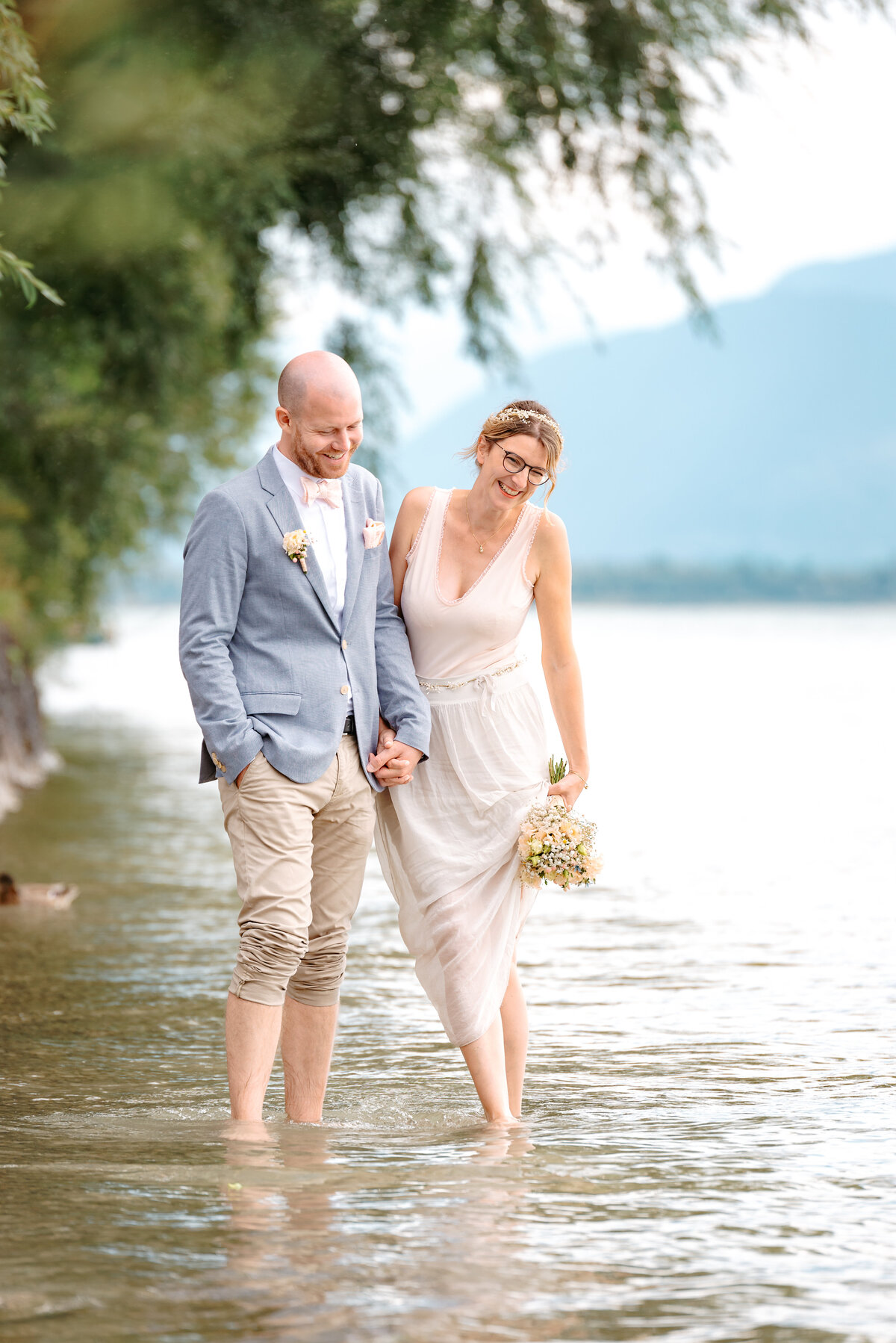 Brautpaar geht Barfuß durch den See Hochzeitsfotograf Chiemsee