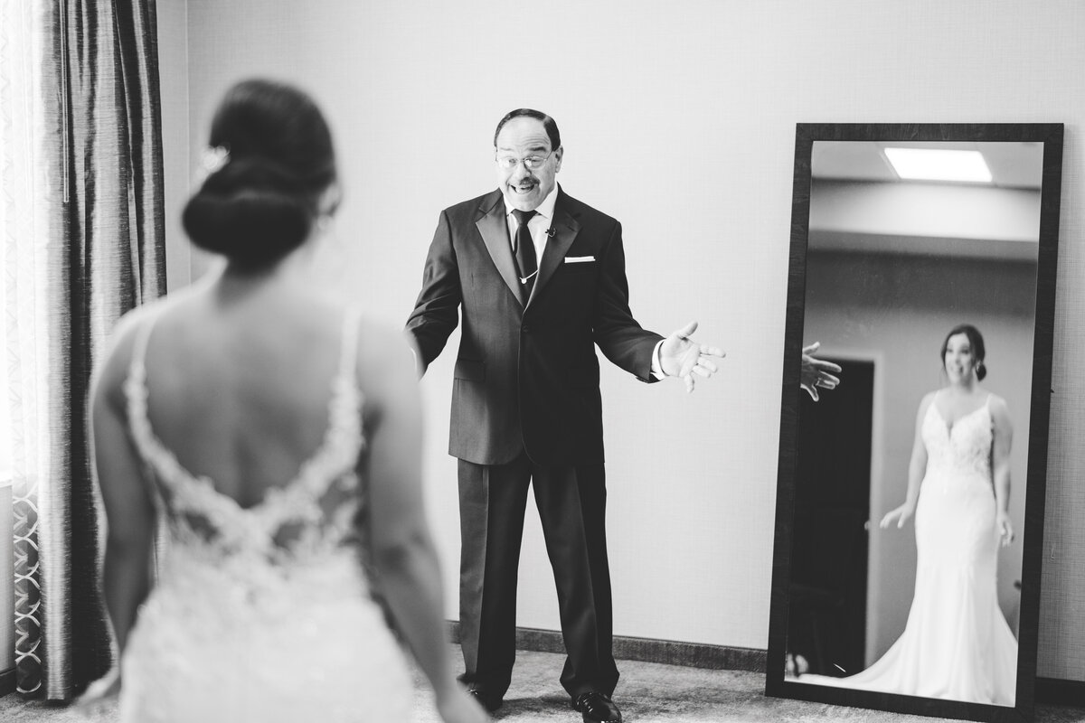 excited father of the bride seeing his daughter in her wedding dress