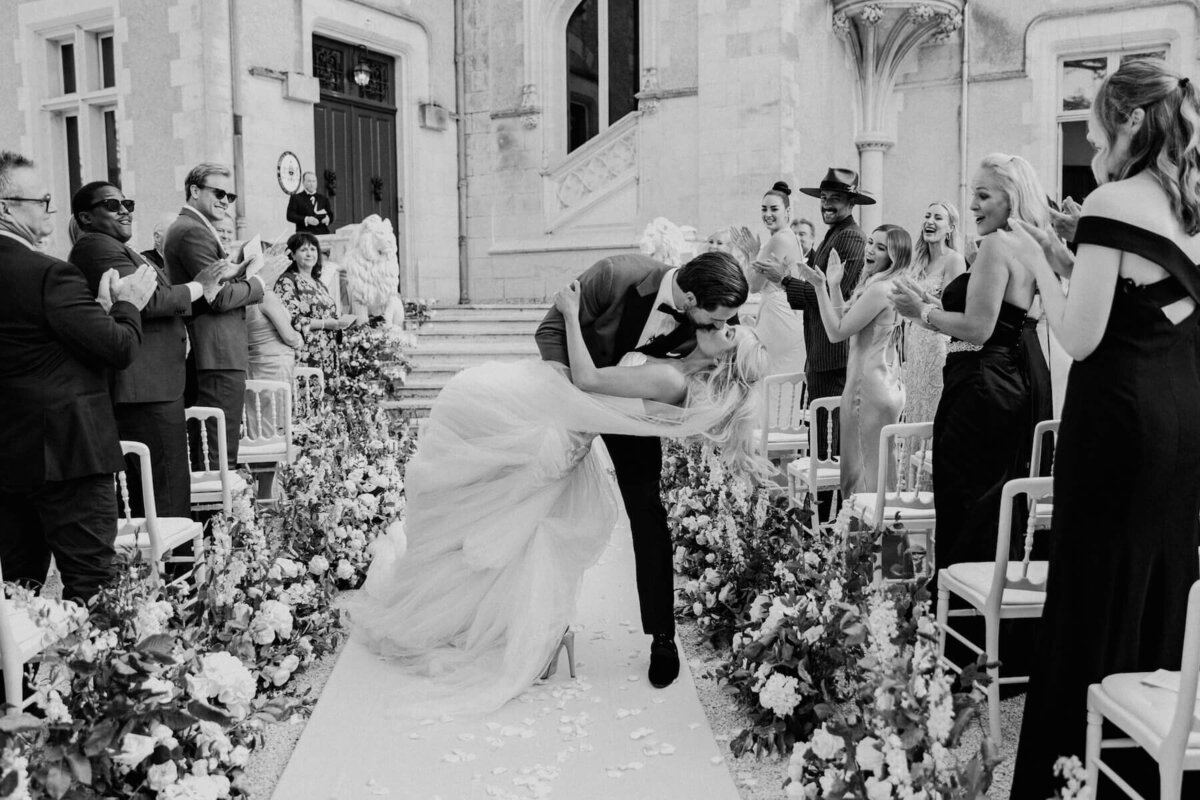 Bride and groom kiss on castle front steps, France