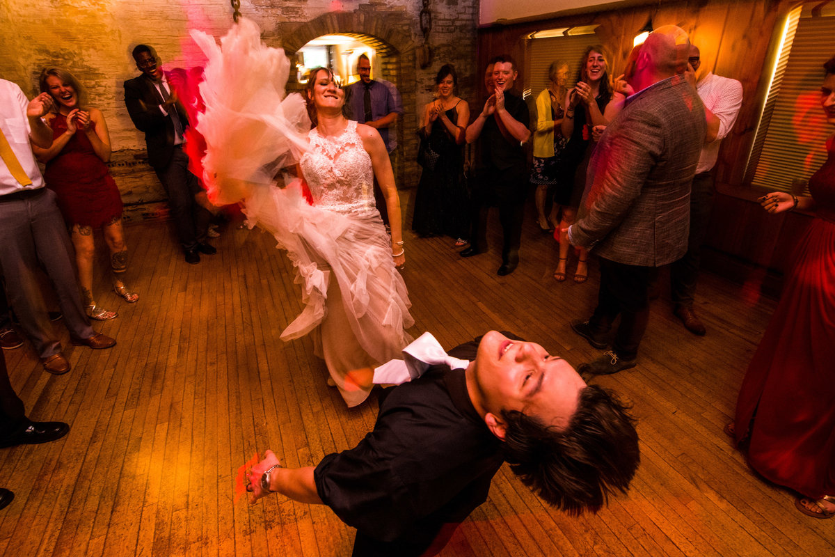 Bride whips dress at groom while dancing.