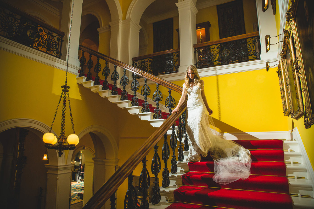 bride stood on the yellow staircase inside capesthorne hall