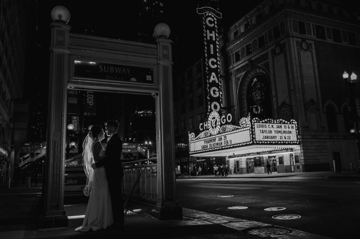 Bride and groom at night in front of the Chicago Theater
