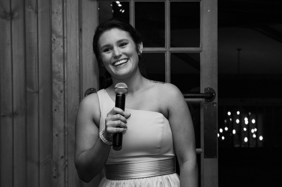 maid of honor toast holding microphone black and white