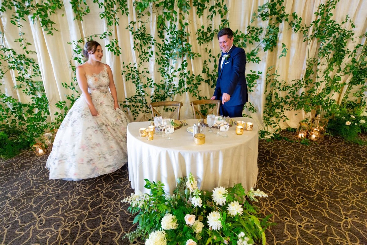 a sweetheart table decorated with greenery