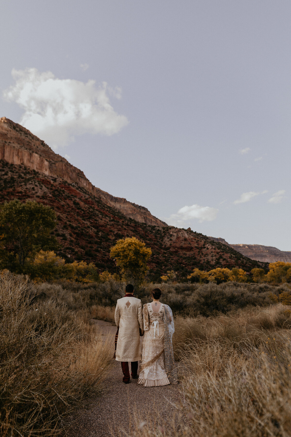 Indian newlyweds walking along the red rocks in Jemez Springs, New Mexico