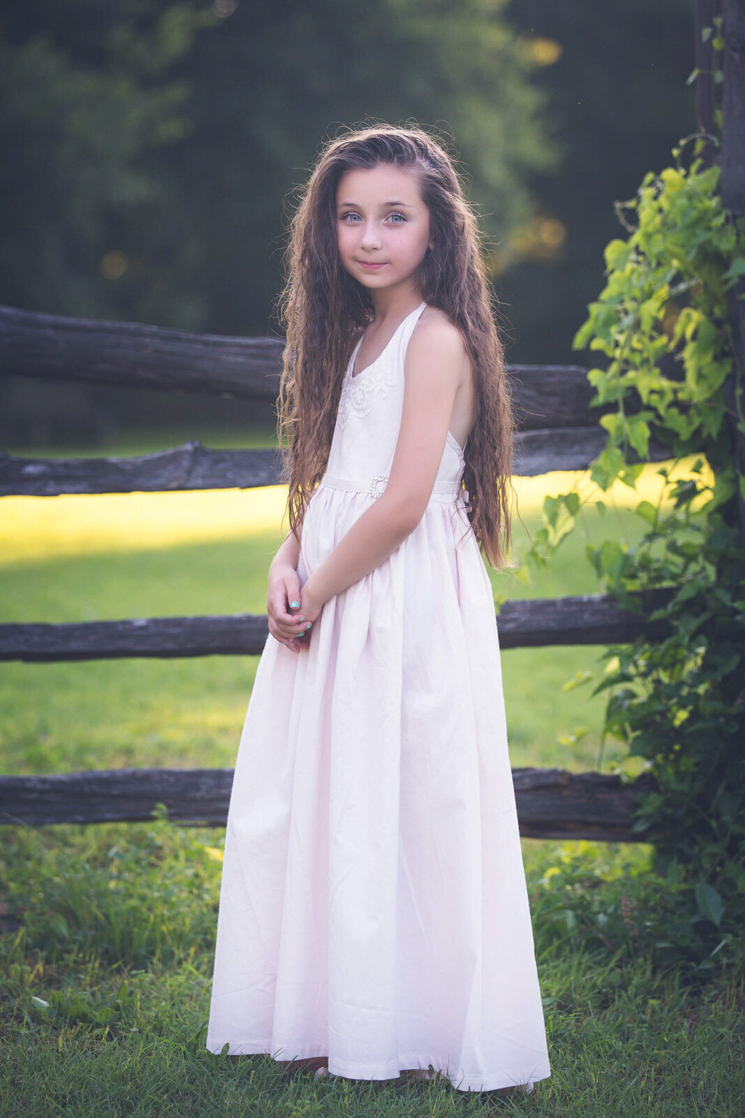 girl-standing-by-fence-in-white-dollcake-dress