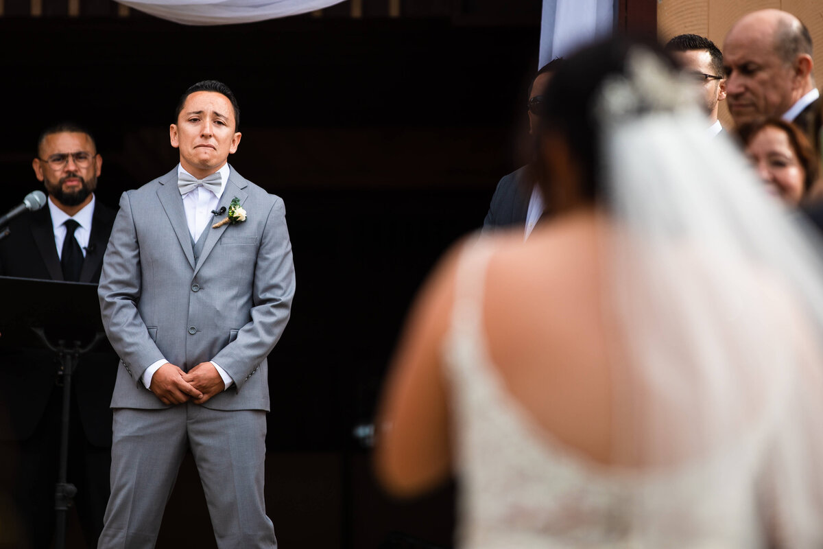 Groom looking emotional as bride walks towards him at Southern California wedding
