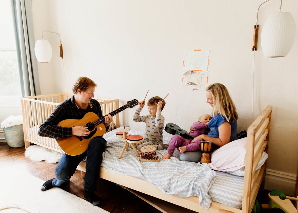 San Francisco in home family photography session of family playing music and mom nursing baby