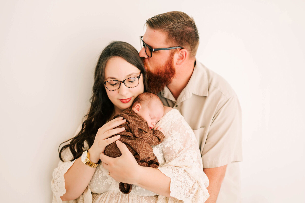 family cuddling newborn captured by Springfield MO newborn photographer Jessica Kennedy of The XO Photography