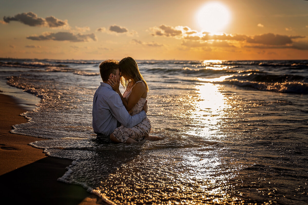 Engagement pictures during sunset of a couple that is in love, washed to shore by waves of Lake Michigan.