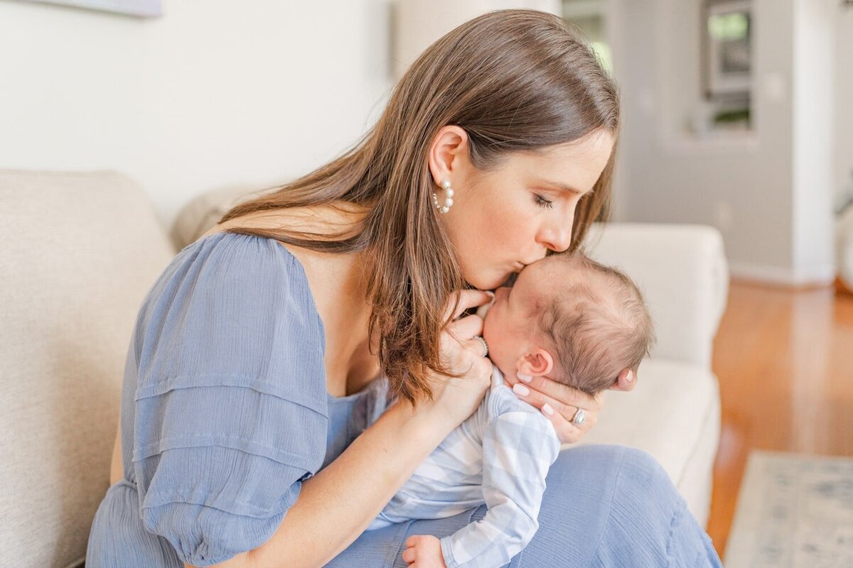mom kissing baby boy during in home newborn photos in Ashburn, Virginia