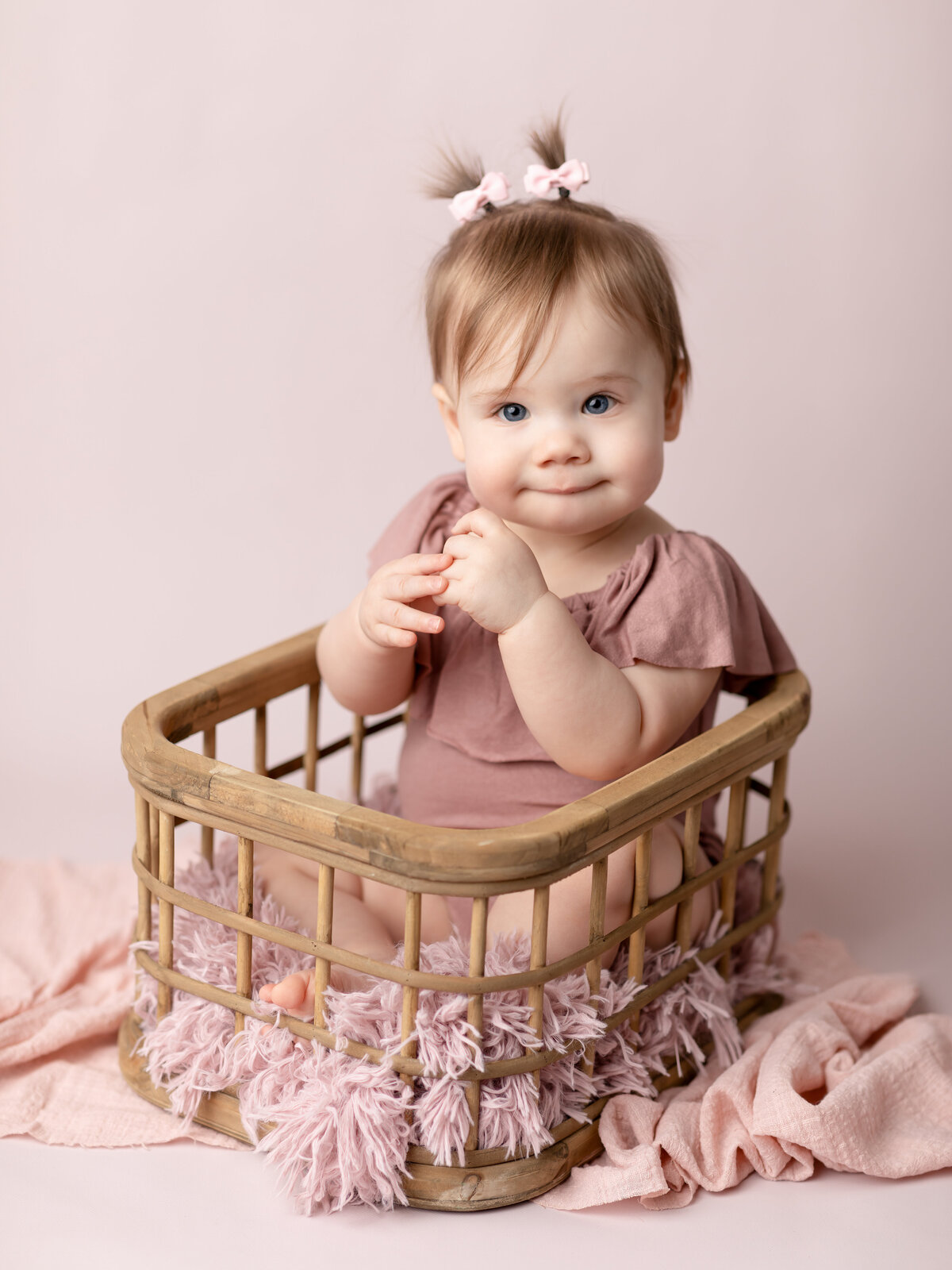 one year old girl in pink for first birthday photoshoot