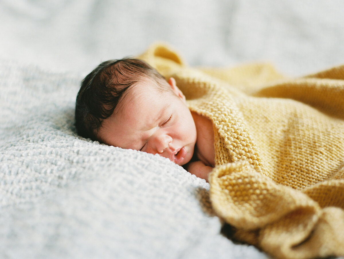 baby in mustard colored blanket by New Hampshire based newborn photographer