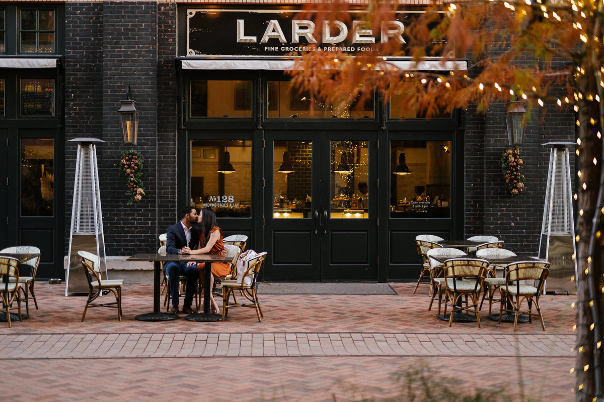 Couple sitting in front of Larder at the Historic Pearl on their engagement session.