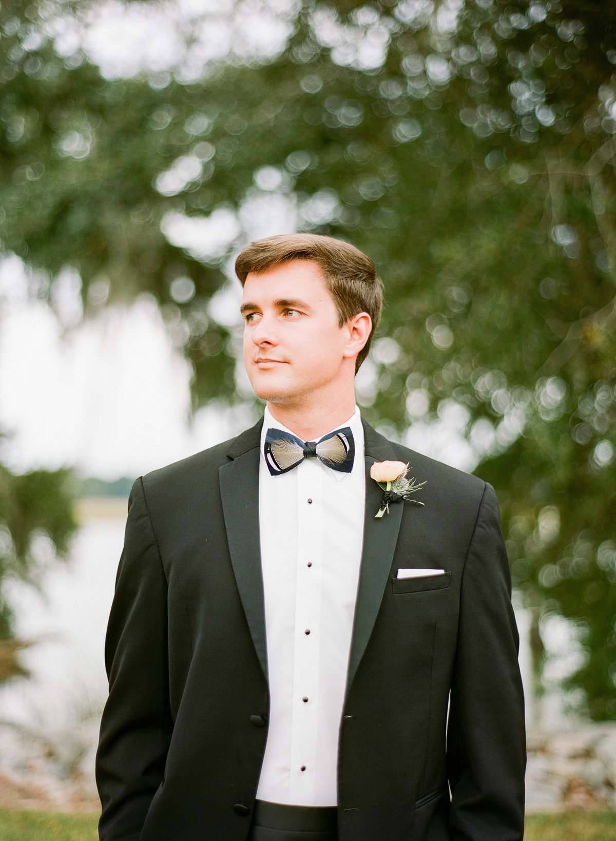 Groom in Black Tuxedo with Feather Brackish Bow Tie Southern Wedding