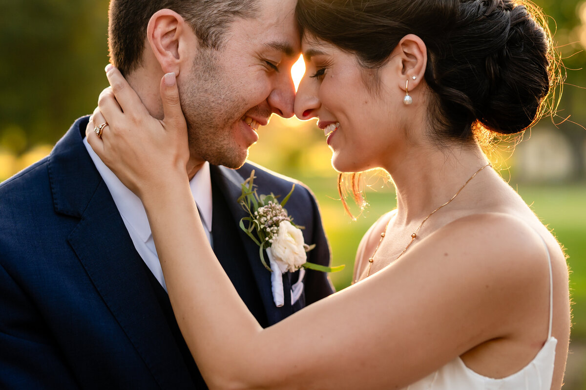 Bride an groom touch foreheads at sunset at Chevy Chase Country Club