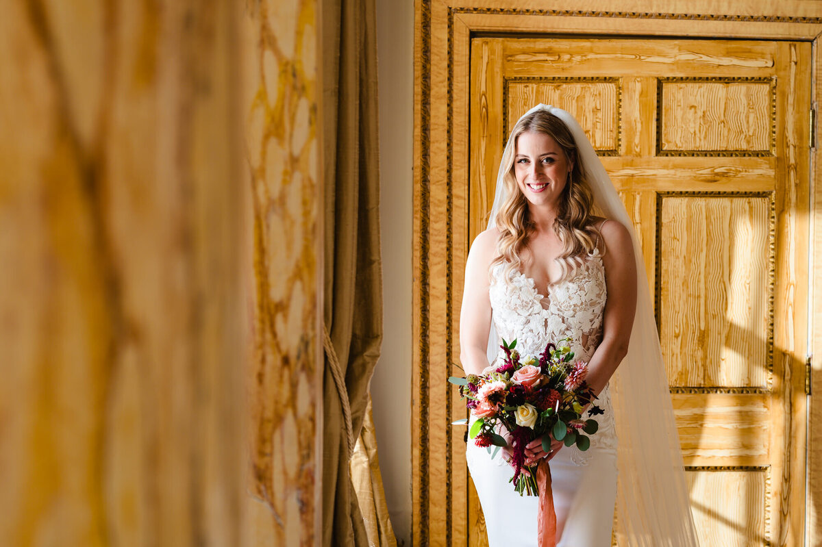Bride standing near the window in the bridal suite at Gosfield hall