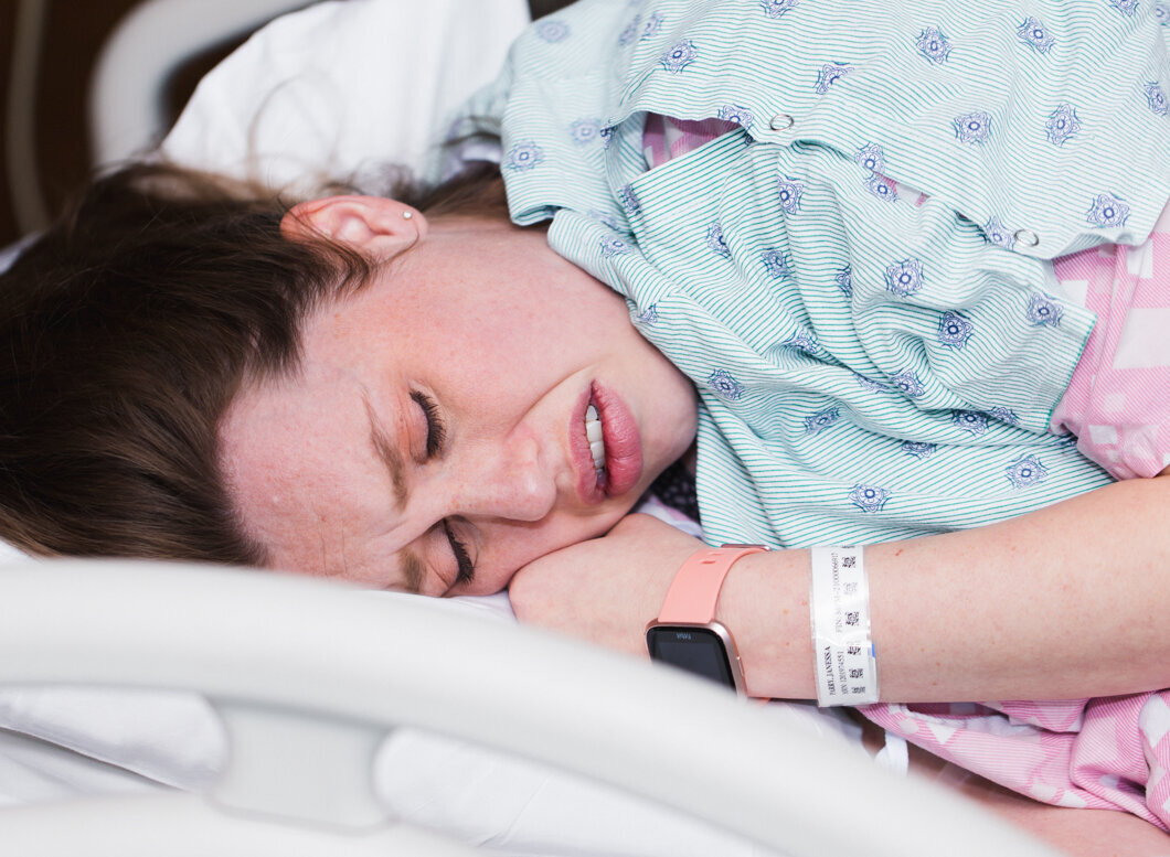 A laboring woman curls up during a contraction at her hospital birth.