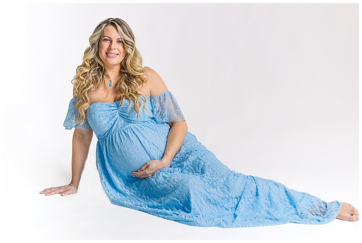 Mom to be showing off her beautiful baby bump in a beautiful blue dress during a maternity photoshoot in studio in Wexford PA