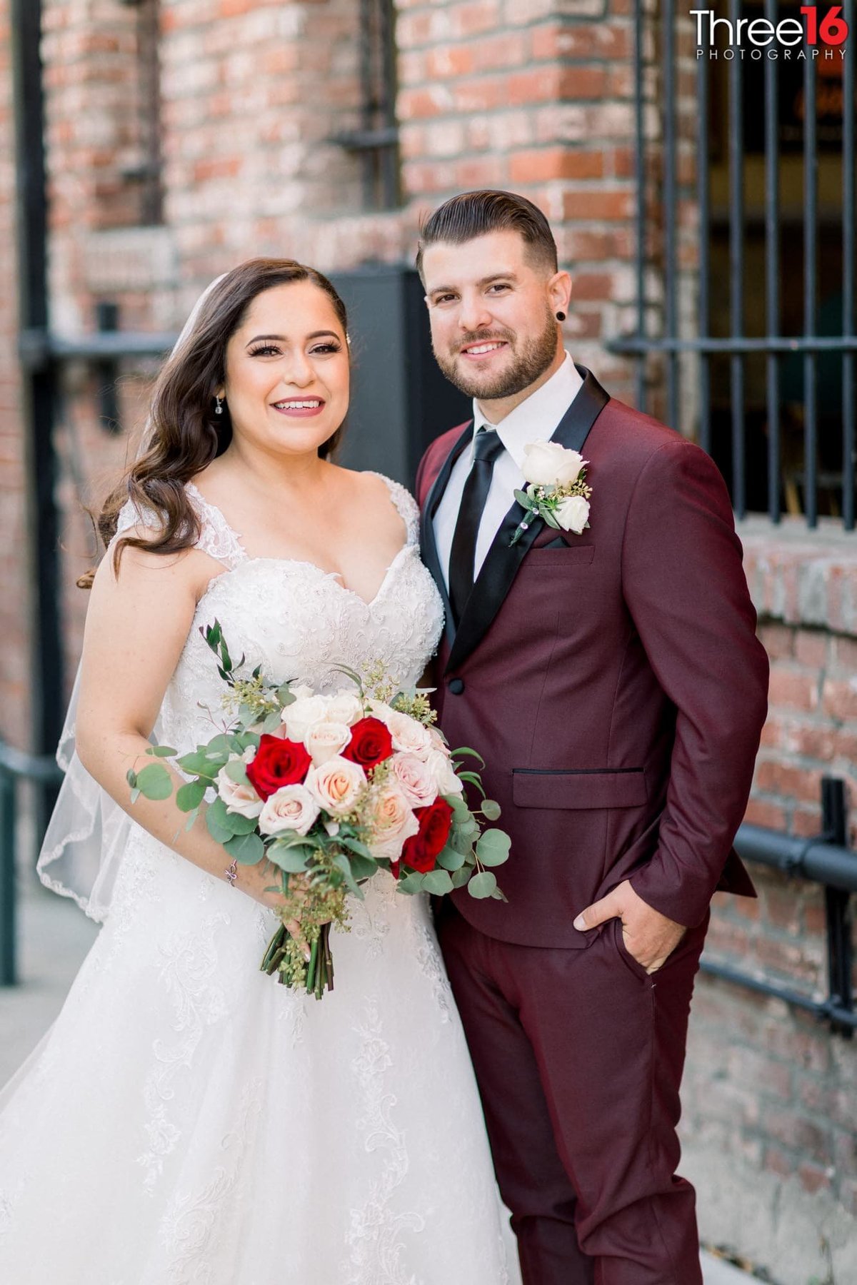 Bride and Groom pose for photos in downtown urban area of Fullerton with brick background