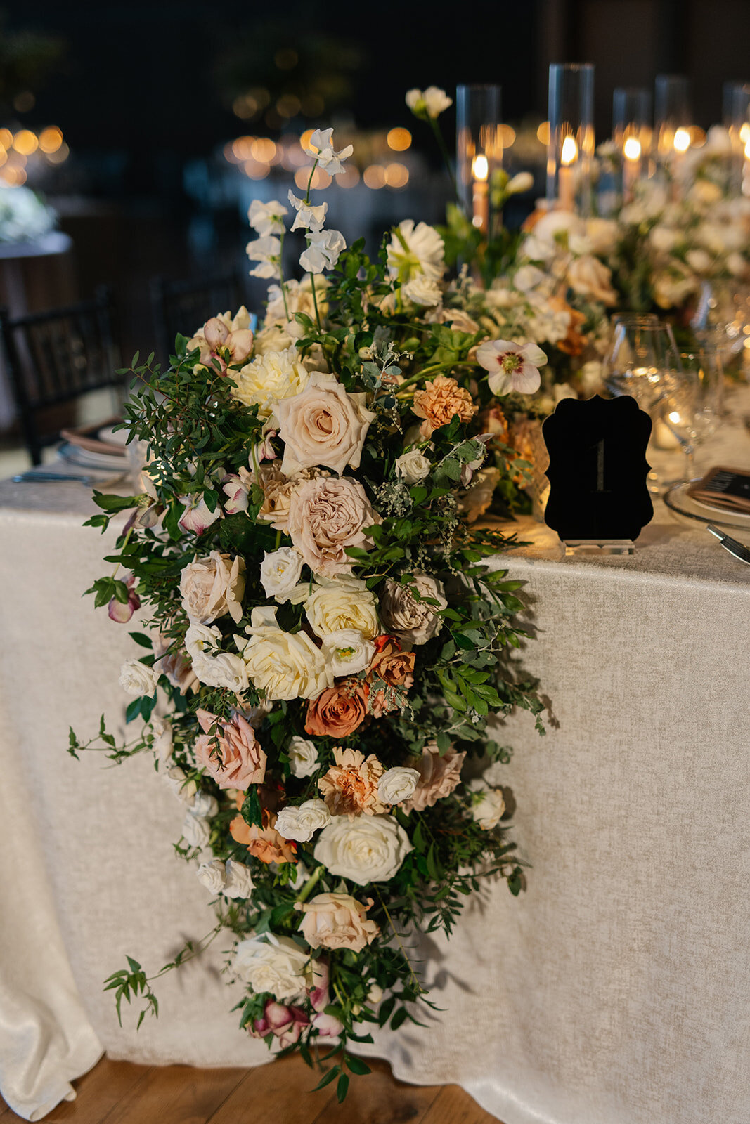 white, blush, orange roses hanging cascading off table