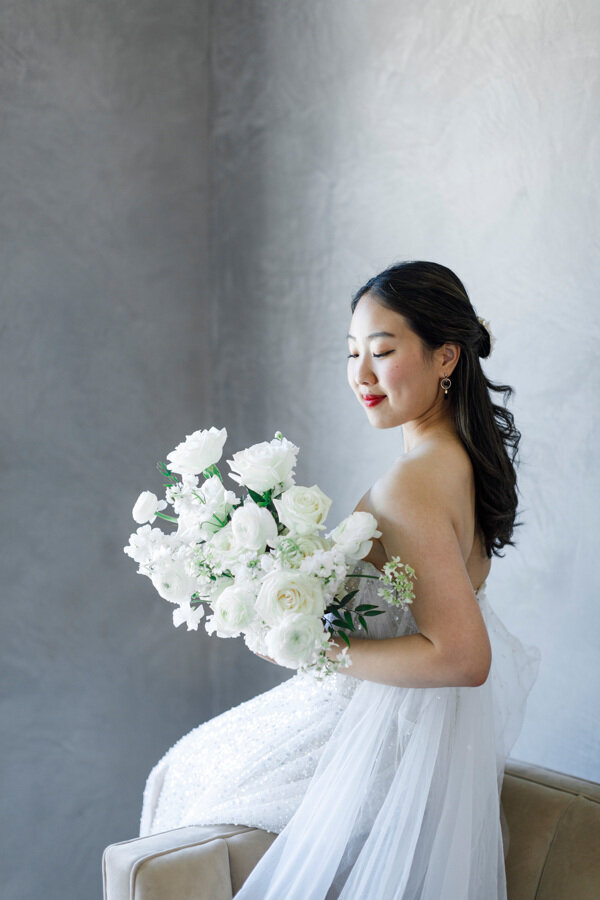 Model with gorgeous white bouquet posing at a wedding editorial shoot