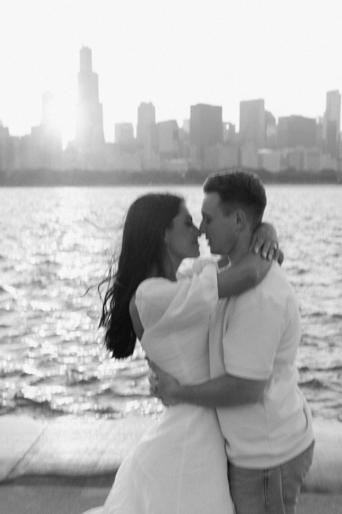 A slightly out of focus black and white engagement photo taken in front of Chicago's skyline