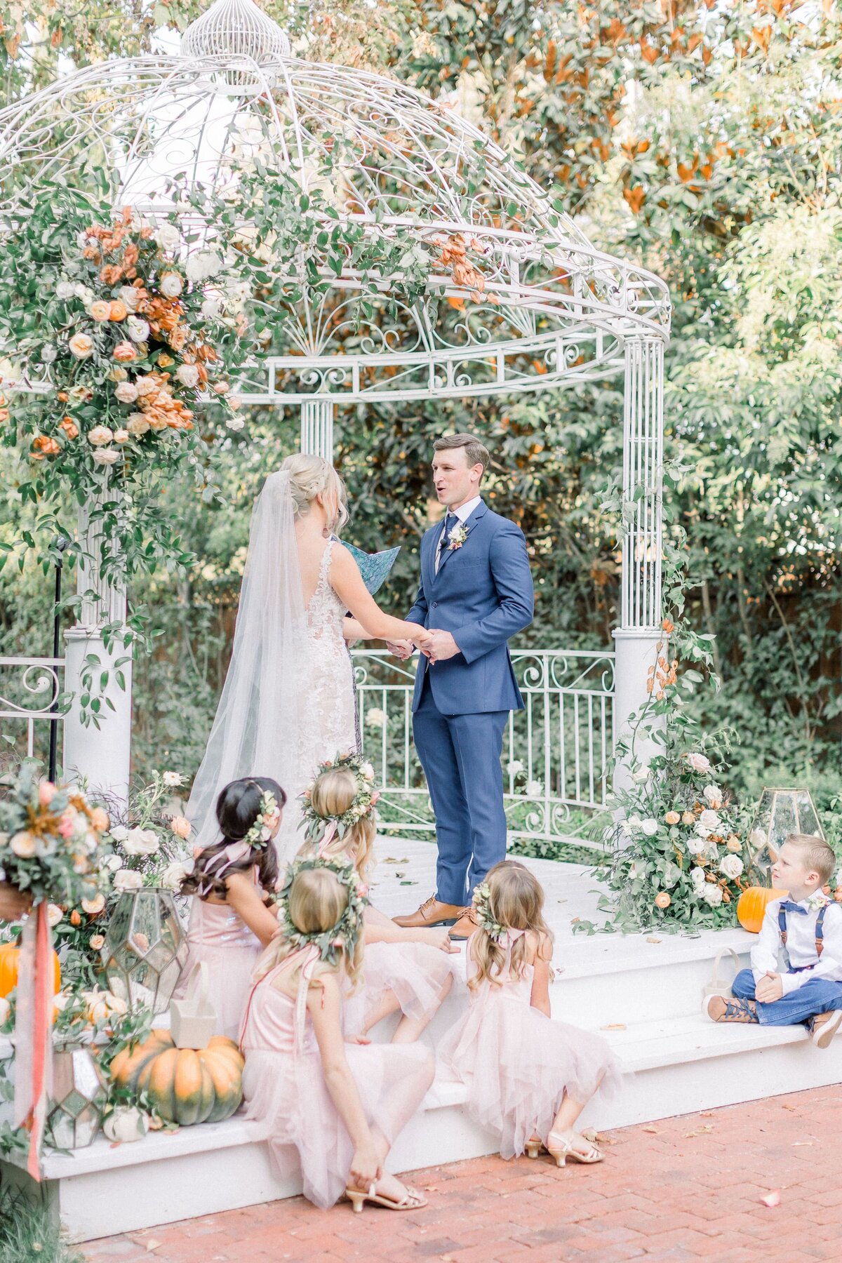 A pumpkin and fall colored floral wedding arbor.