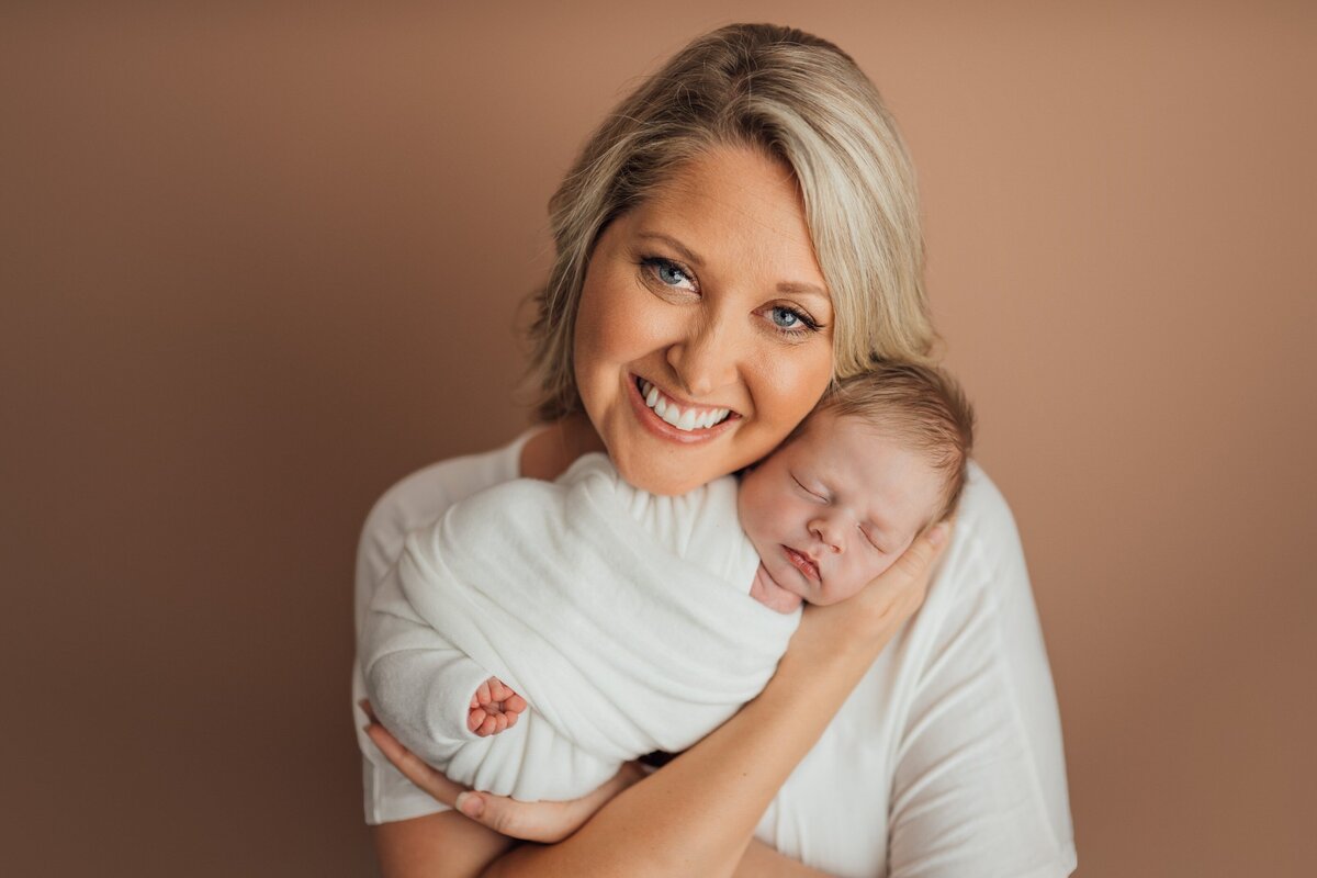 mom holds baby during newborn session in st. pete