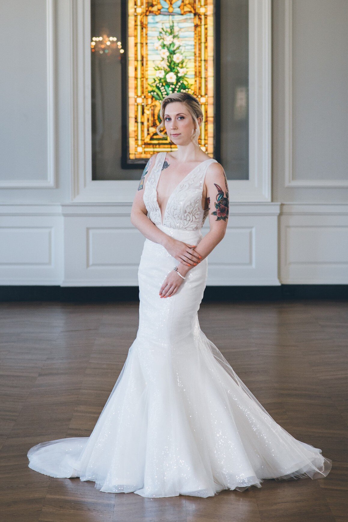 Faven is a plunging v-neck wedding dress style in a mermaid silhouette with a sparkling sequin skirt.
