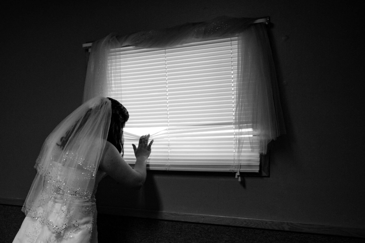 bride peeks at groom outside