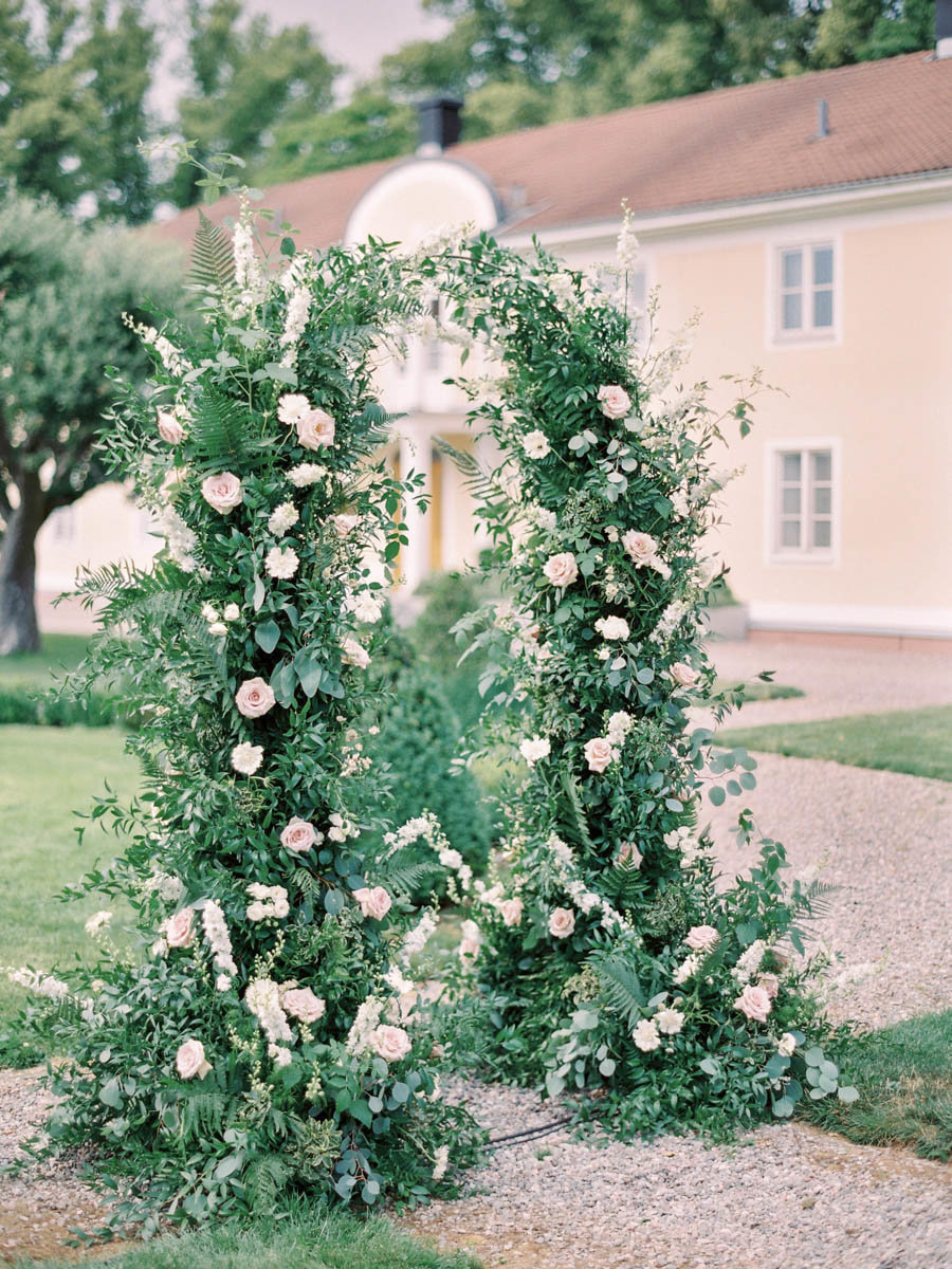 garden inspired wedding ceremony arch with white and blush flowers at Södertuna slott