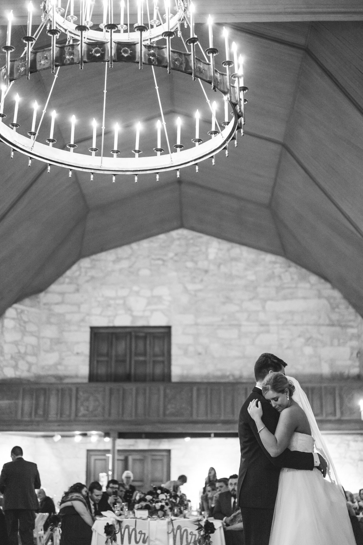 black and white of bride and groom hugging during first dance at wedding reception at The Southwest School of Arts venue