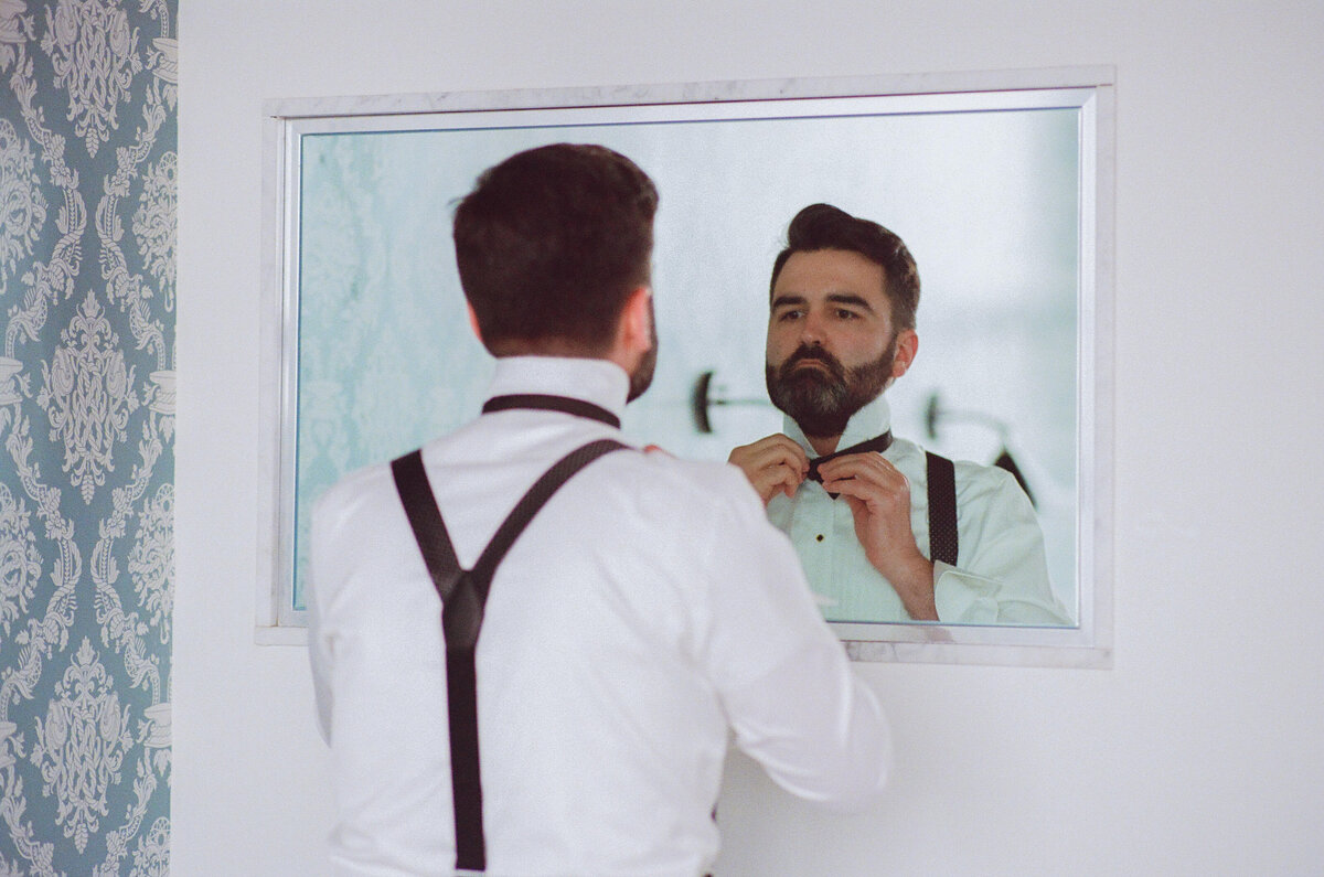 A groom adjusting his collar.