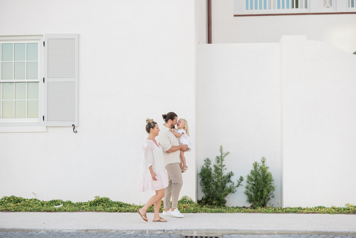 Two parents walking together while one holds a baby