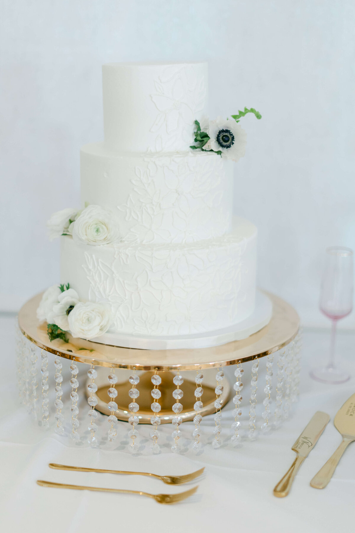 A wedding cake sits on a golden platter.