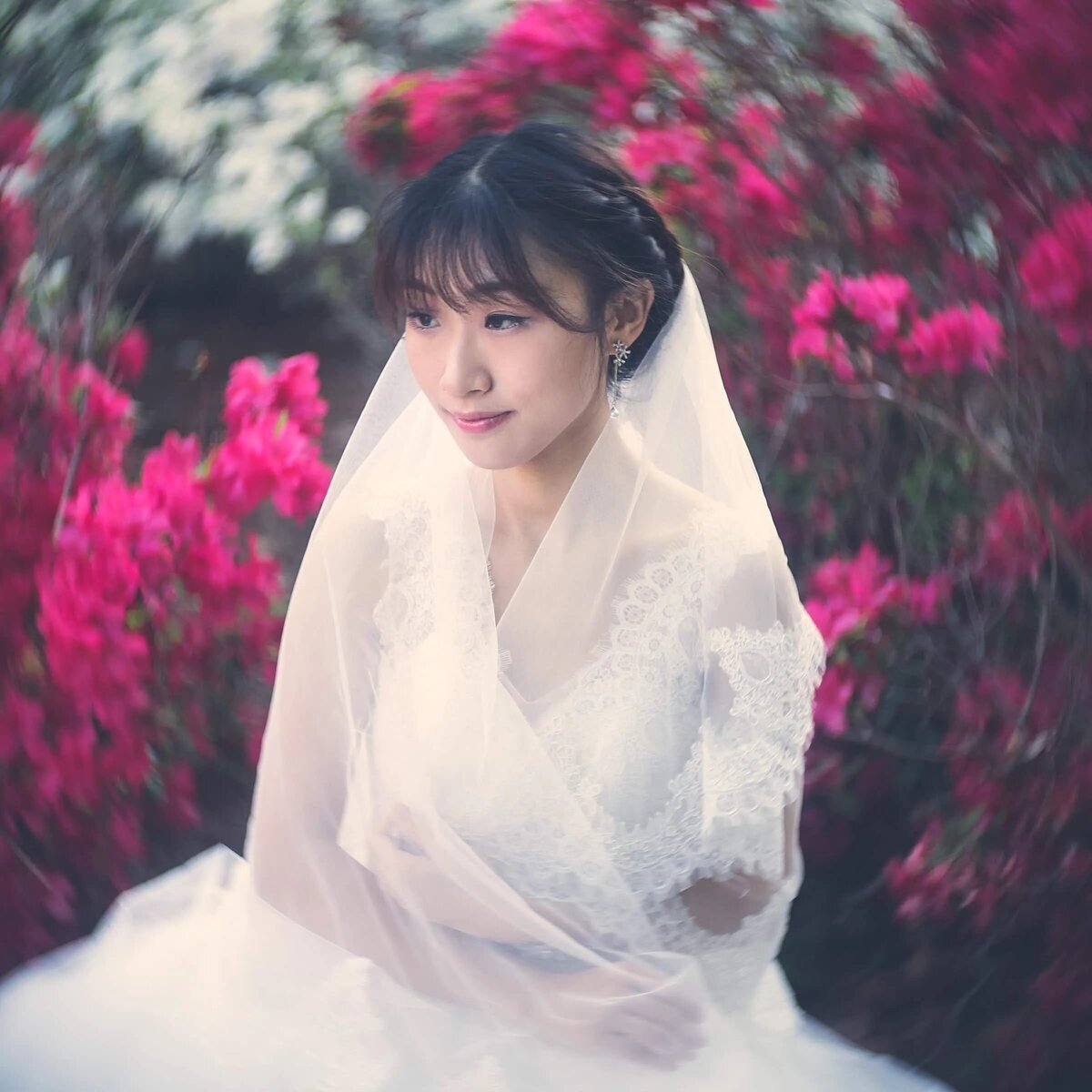 A bride sitting in front of bright flowers