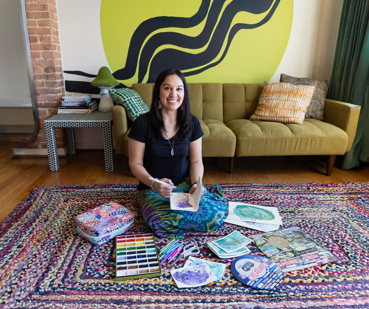 Brand-strategist-smiles-during-her-mixed-media-brand-session-with-her-artwork-in-Baltimore-Maryland