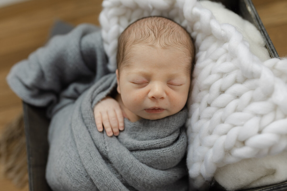 newborn wrapped in blue sleeping