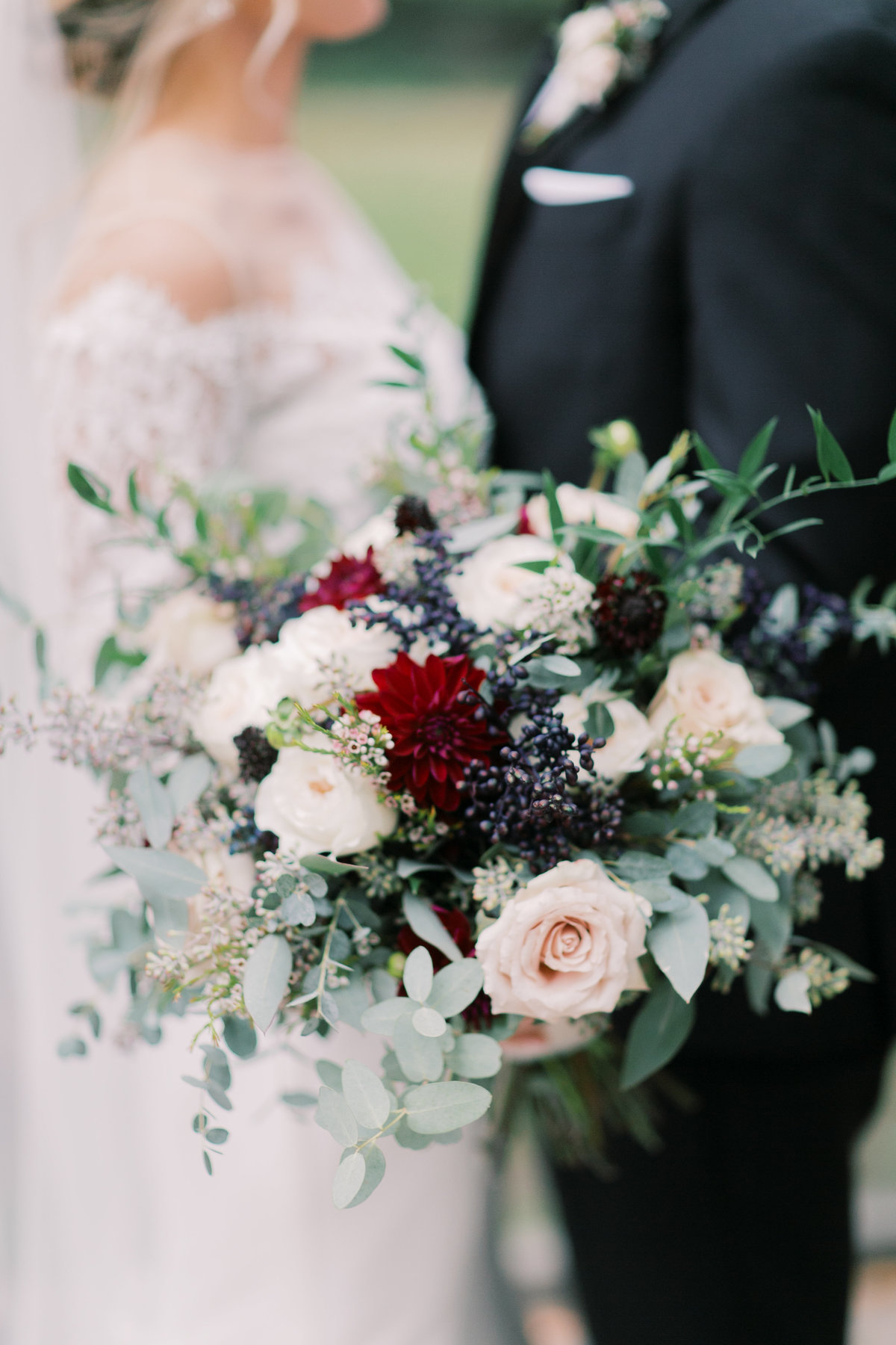 bridal couple holding bouquet of pink flowers and greenery