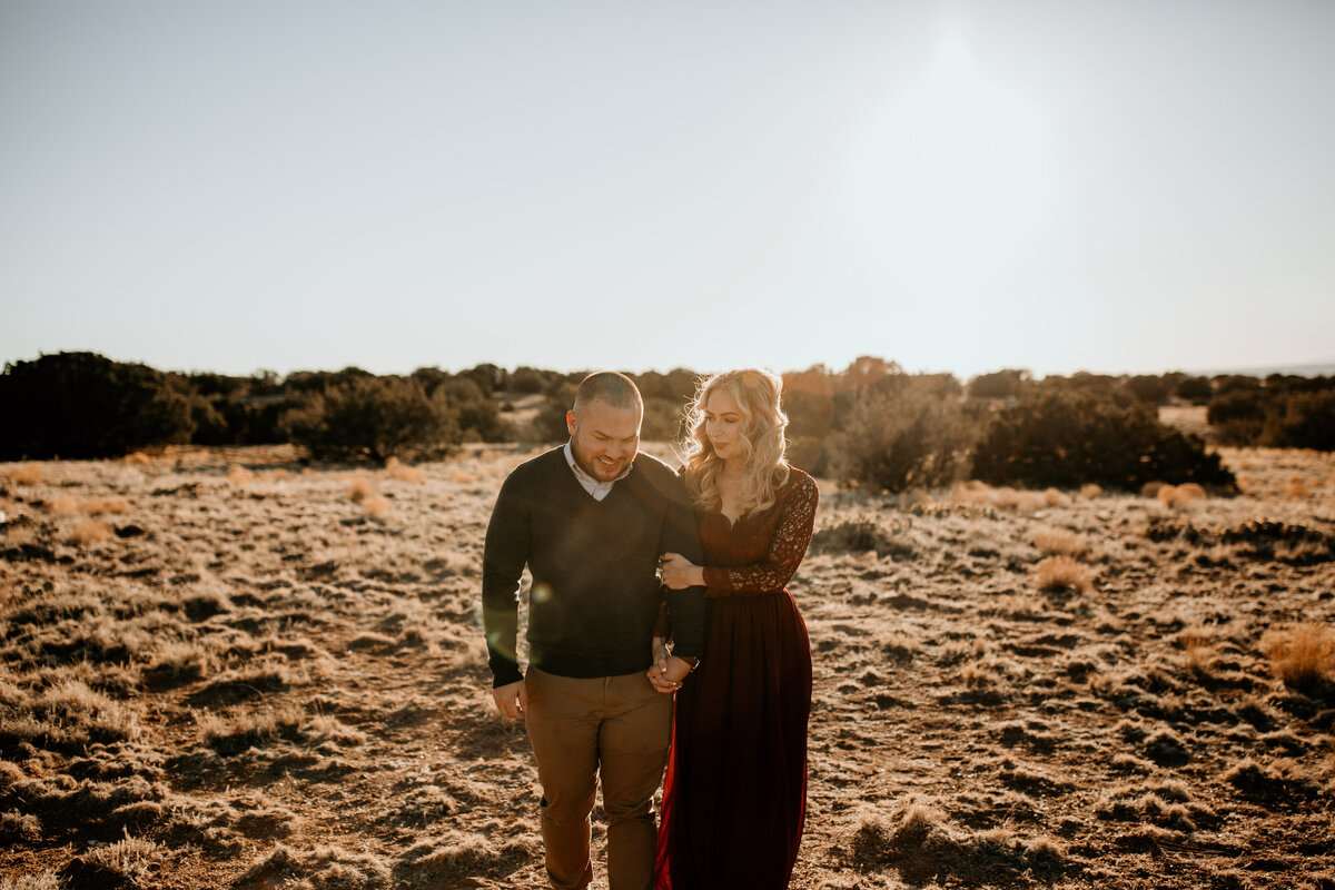 man and woman walking through the desert