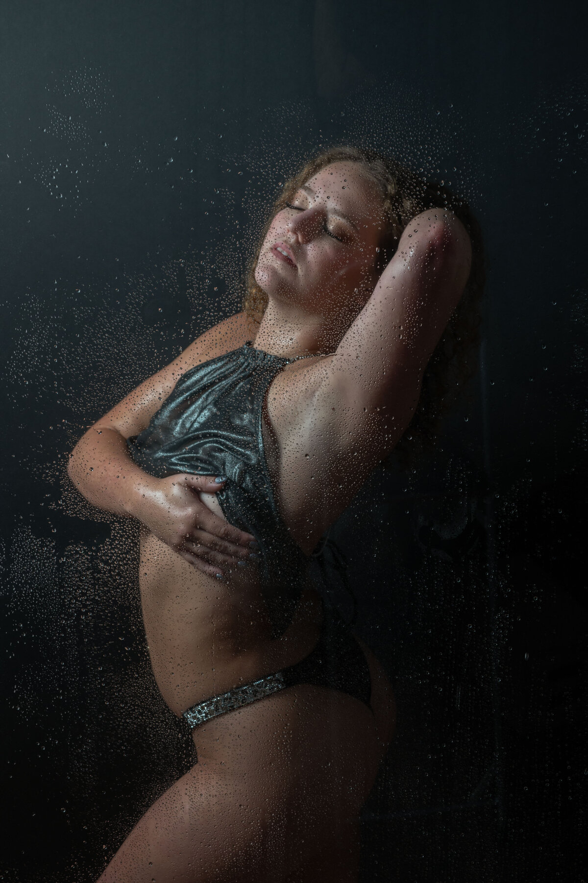 A boudoir shower scene of a woman posing for Khim Higgins Boudoir.