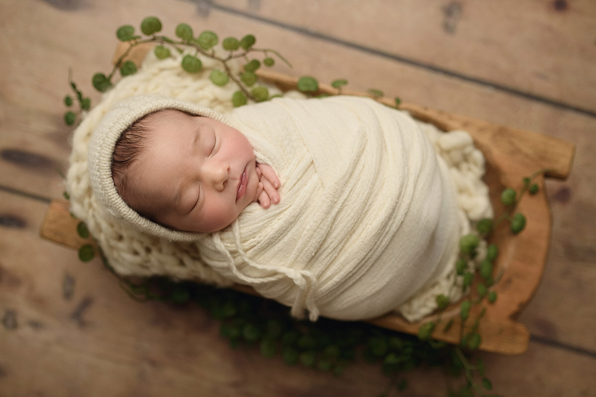 Baby wrapped in cream blanket by boston newborn photographer