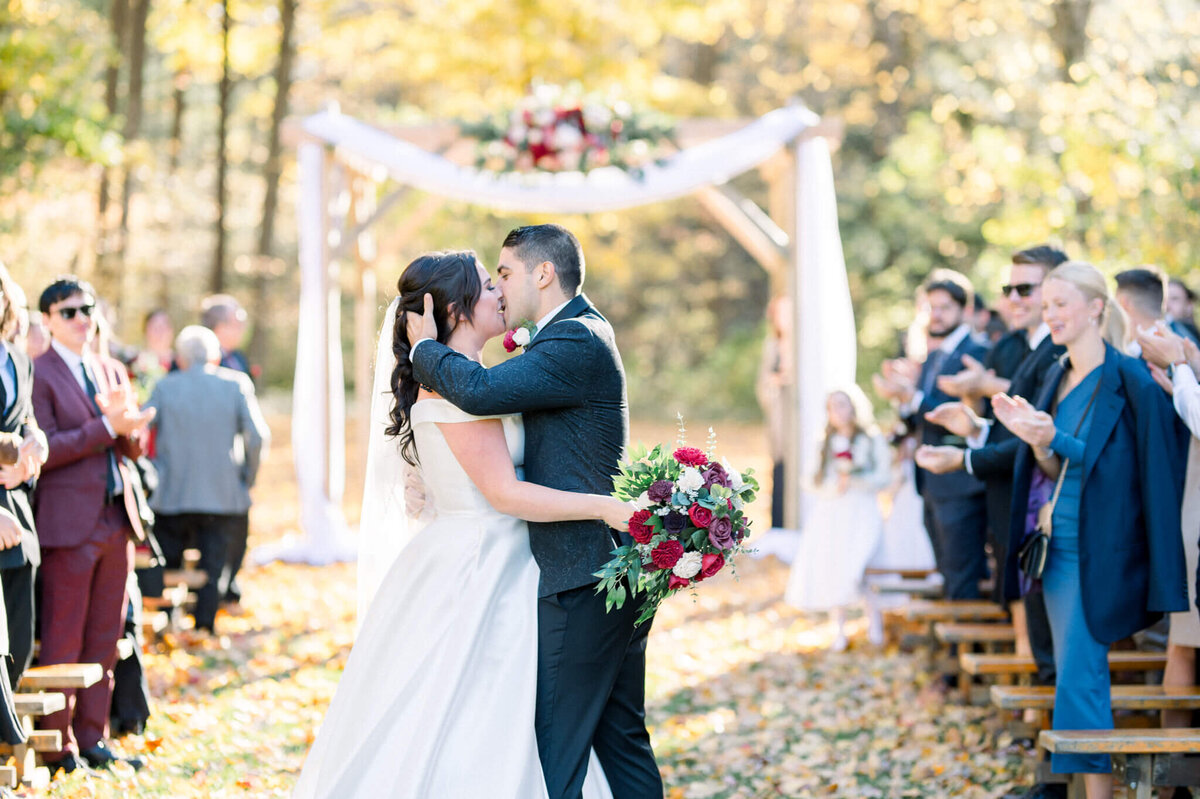 Niagara wedding photographer captures Bride and Groom kiss at the top of the aisle in front of their guests