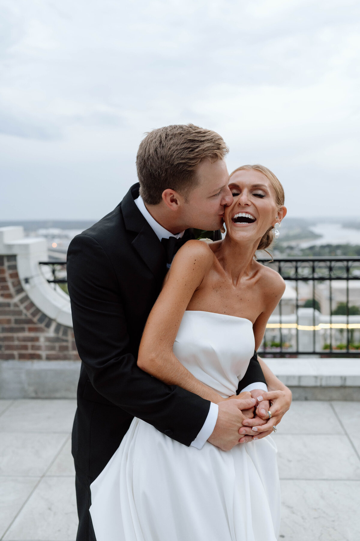 groom kissing brides cheek after their wedding ceremony in tulsa ok at the mayo hotel