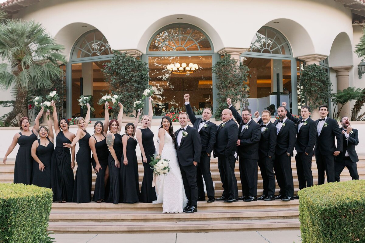 The bridal party is in all black to make the bride's white dress and white bouquet stand out in a bold way.