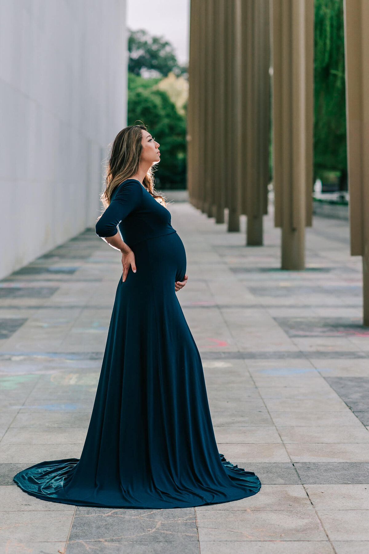 A radiant mama holding her belly by a Northern Virginia maternity photographer, Denise Van