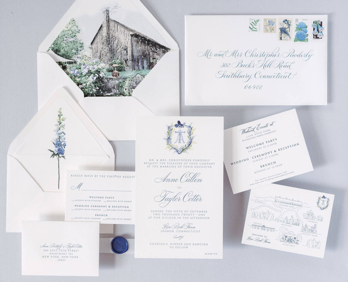 Pretty, traditional wedding invitation cards with envelopes and stamps are laid out on a table. Image by Jenny Fu Studio